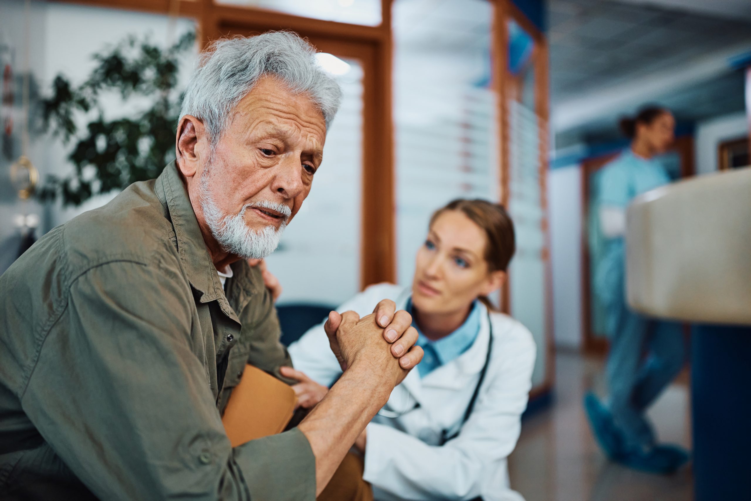 Worried senior man with female doctor in waiting room at the clinic. Worried senior man with female doctor in waiting room at the clinic.