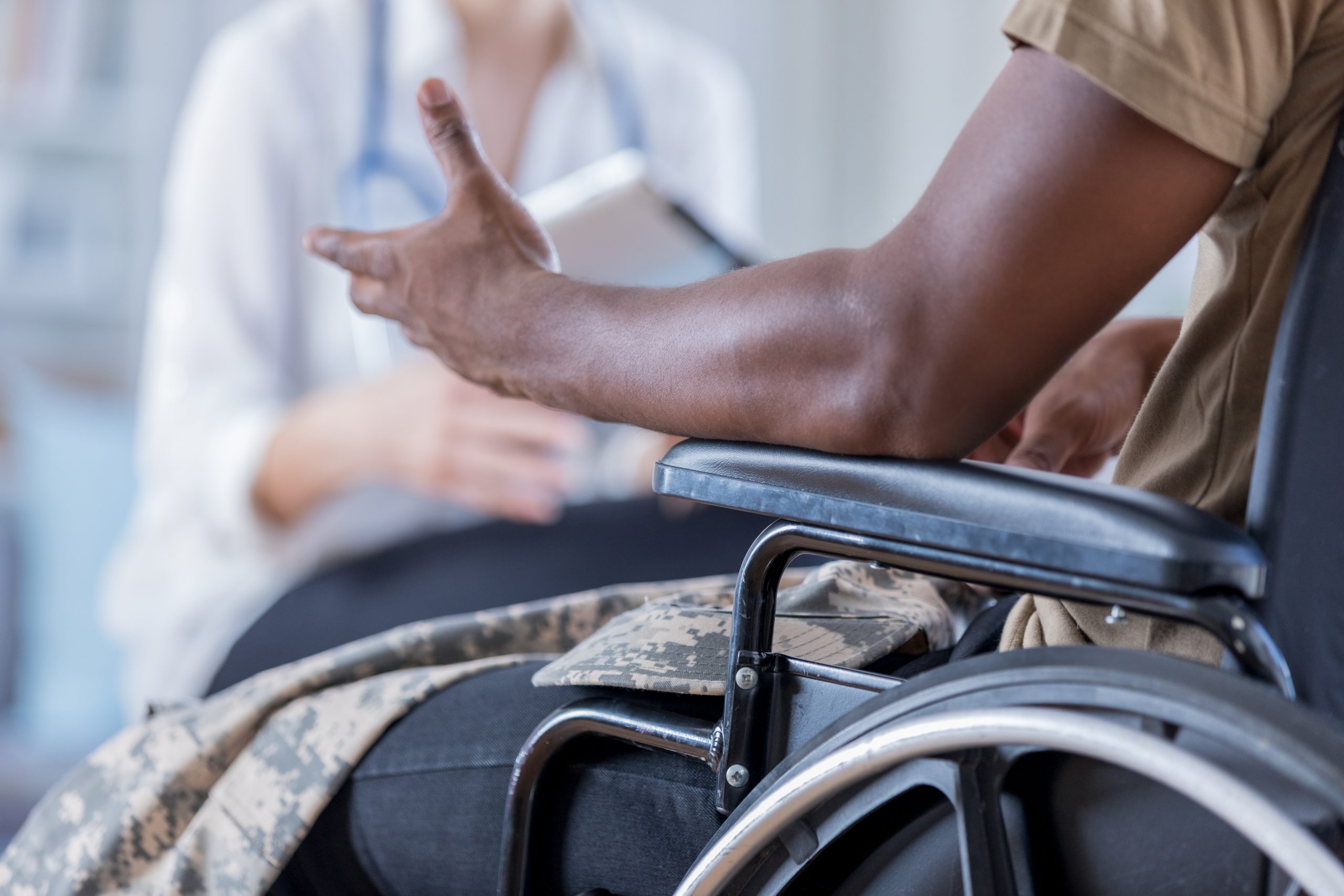 Unrecognizable wounded warrior discusses symptoms with doctor Unrecognizable wounded warrior discusses symptoms with doctor