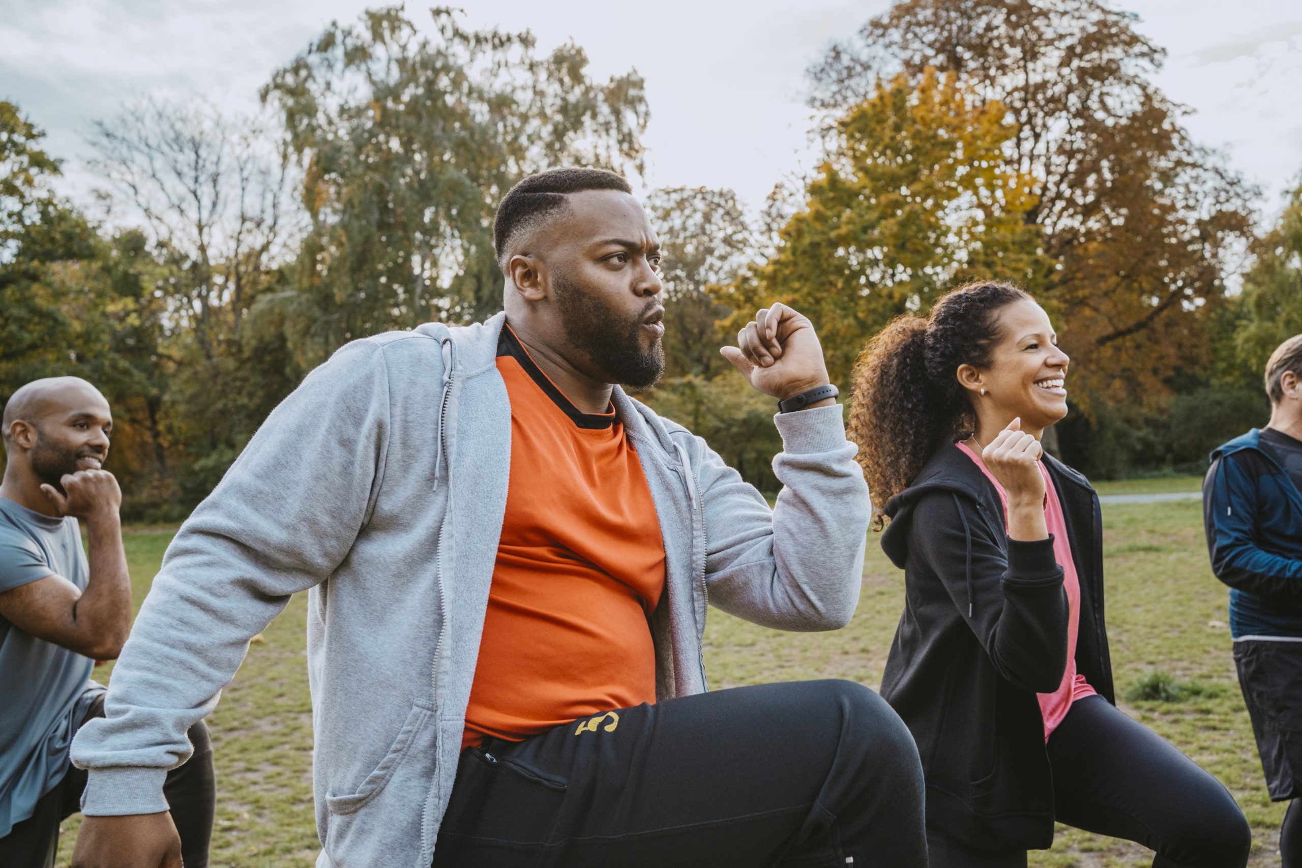 Multiracial male and female friends exercising in park friends exercising